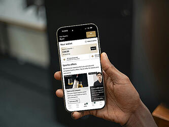 Hand holding smartphone, with screen displaying digital interface of M&S customer rewards programme